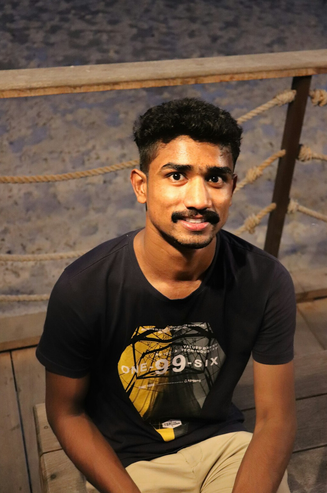 Portrait of a man in a navy shirt smiling at the camera