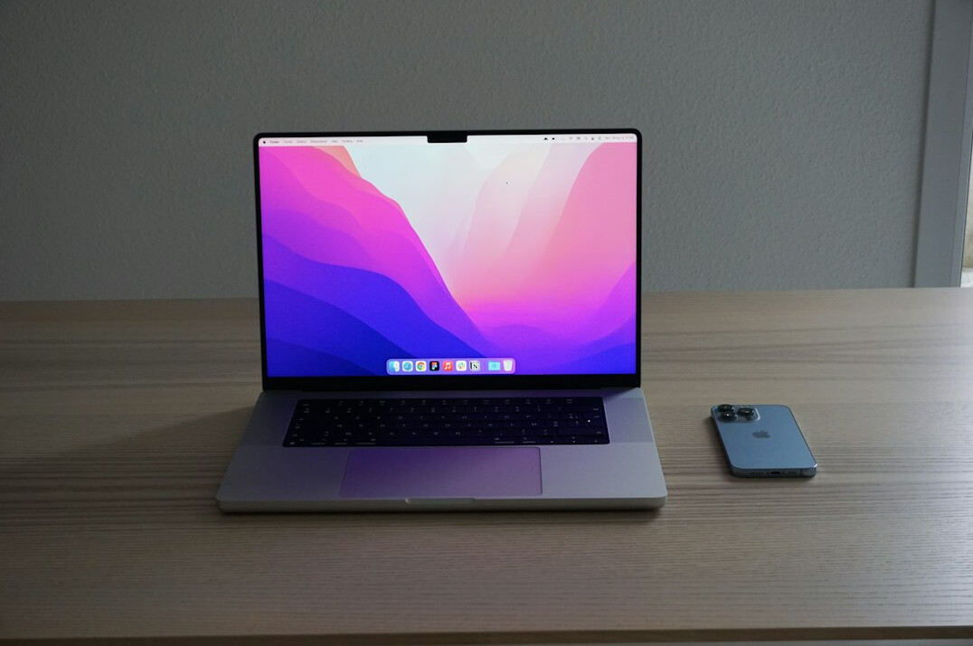 Laptop showing analytics dashboard on a desk beside a notebook